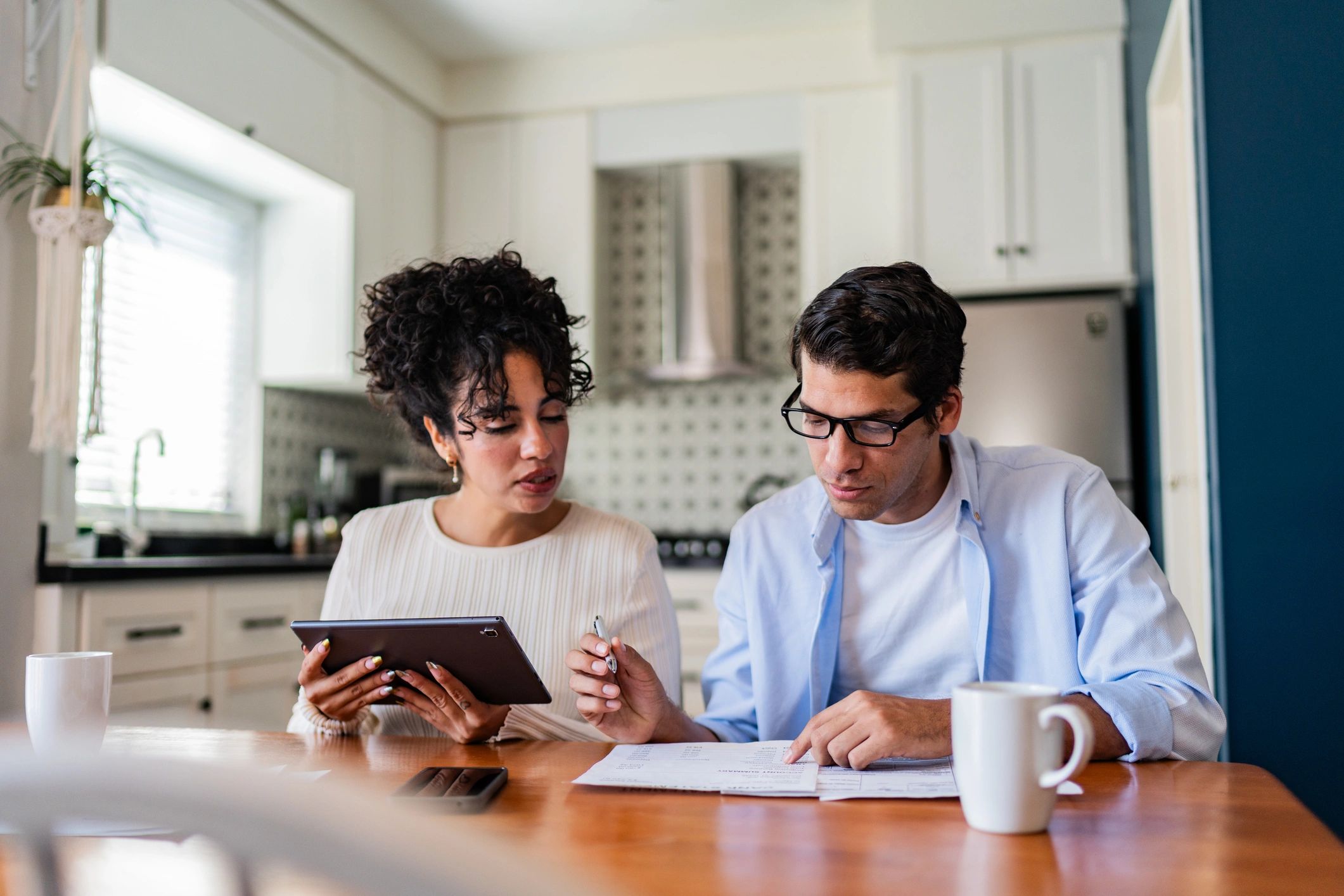 Homeowners reviewing paperwork together at a kitchen table